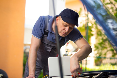 Car mechanic working in auto repair service.