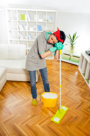 Young woman cleaning and mopping floor at home.の写真素材