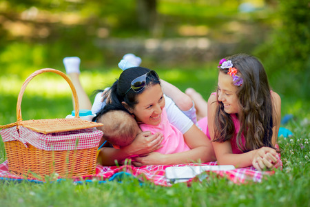 Mother with children enjoying at the picnicの写真素材