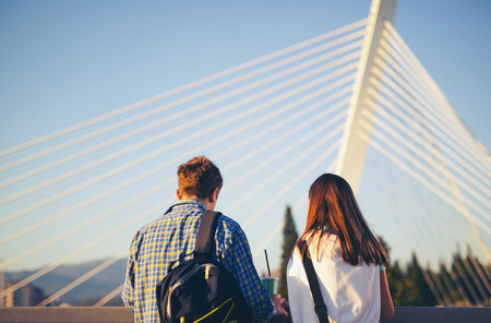 Two teenagers friends standing on the bridge and watch the riverの写真素材