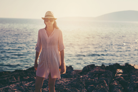 Woman standing on the cape by the seaの写真素材