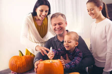 Family carving pumpkin for Halloweenの写真素材
