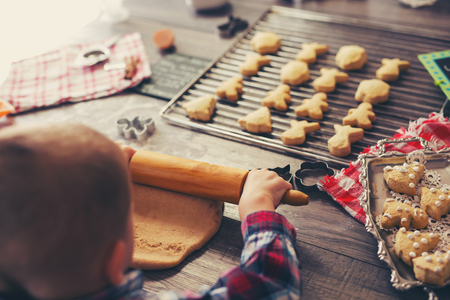 Child rolling out dough for christmas cookiesの写真素材