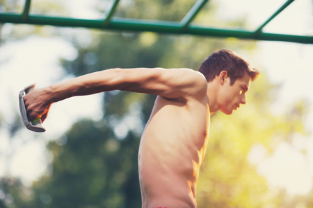 Well built muscular man doing a physical exercise outdoorsの写真素材
