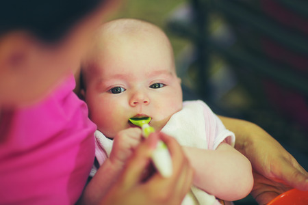 Mother feeding baby girl food to babyの写真素材