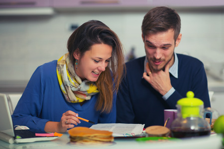 Cute couple doing documentation for home budgeting at home in the kitchenの写真素材