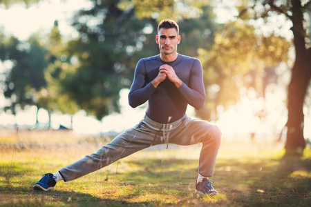 Handsome man exercising in forestの写真素材