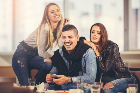 Young friends having a great time in restaurantの写真素材