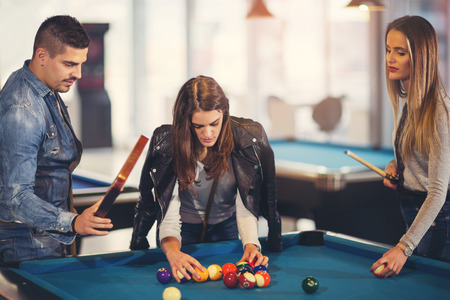 Group of young friends playing billiard