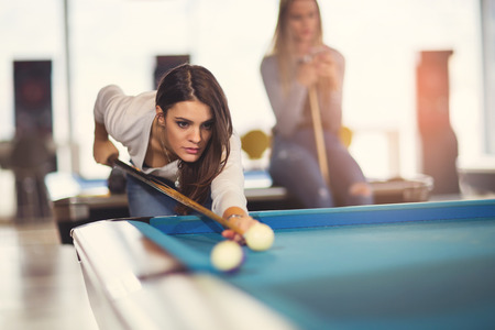 Group of young friends playing billiard