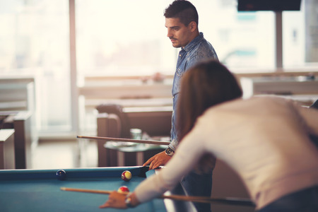 Group of young friends playing billiard