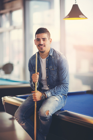 Handsome man playing pool in pub