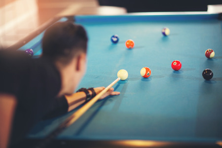 Handsome man playing pool in pub
