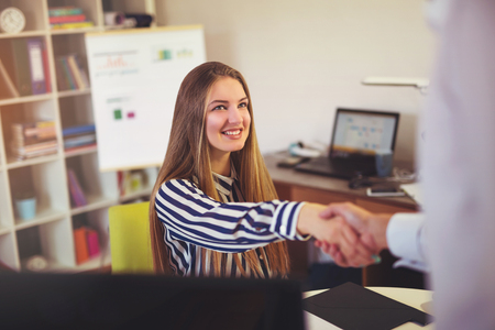 Two successful business partner shaking hands in the officeの写真素材