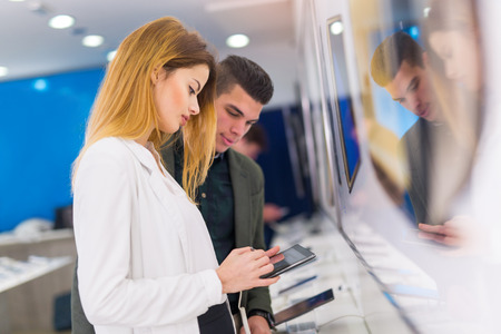 Two people are choosing digital tablet in the storeの写真素材