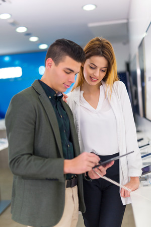 Two people are choosing digital tablet in the storeの写真素材