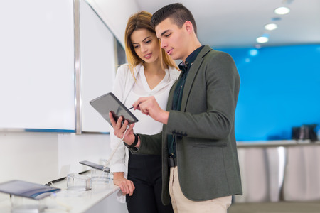 Two people are choosing digital tablet in the storeの写真素材