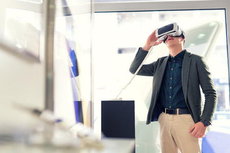 Attractive young man is holding 3D glasses in the storeの写真素材