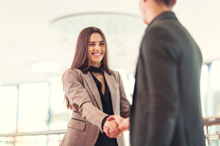 Welcoming business woman giving a handshake and smilingの写真素材