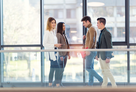 Four colleagues meet in the hallway office building