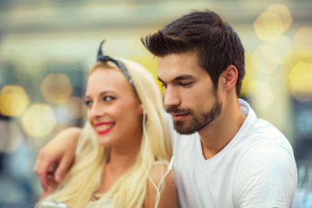 Happy young couple in love sitting on a benchの写真素材