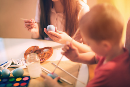 Children paint Easter eggs at homeの写真素材