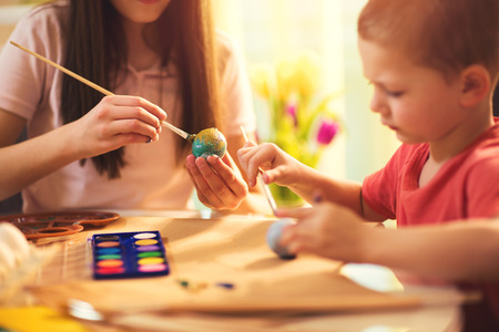 Children paint Easter eggs at homeの写真素材