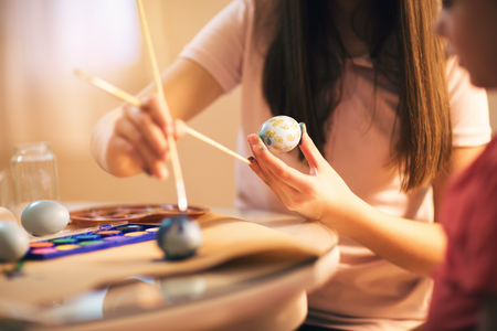 Children paint Easter eggs at homeの写真素材