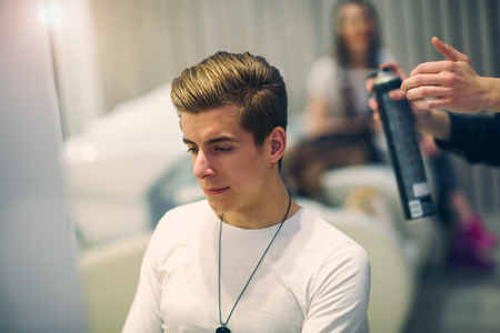 Handsome man at the hairdresser getting a new haircutの写真素材
