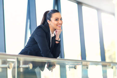 Attractive business woman standing in the hallway of the office building looking at cameraの写真素材