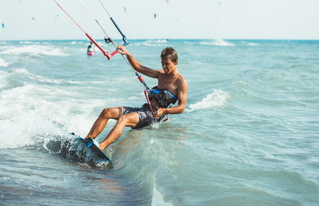 Kitesurfing, Kiteboarding action photos, man among waves quickly goesの写真素材