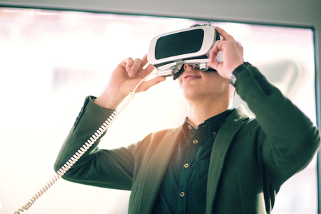 Attractive young man is holding 3D glasses in the storeの写真素材