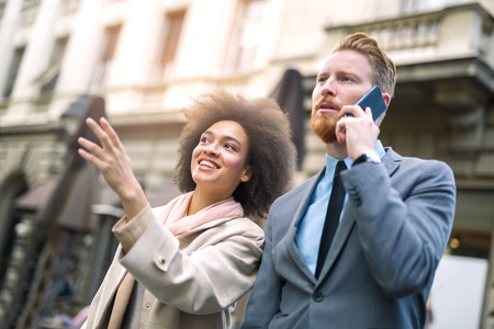 Two business people in an informal conversation in front of a business building