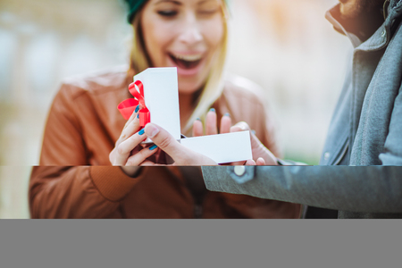 Couple in love.Man surprising his girlfriend with a gift.の写真素材