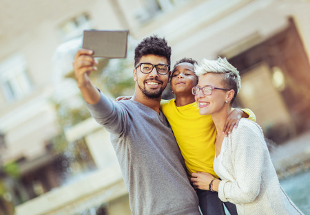 Happy young mixed race couple spending time with their daughterの写真素材