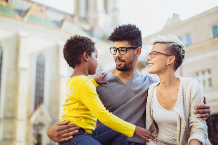 Happy young mixed race couple spending time with their daughterの写真素材