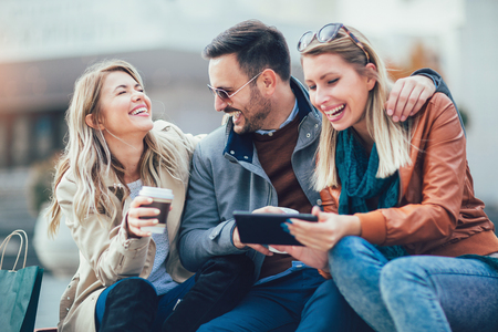 Group of smiling friends with digital tablet outdoorの写真素材