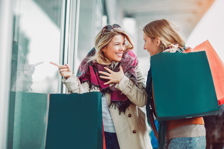 Happy friends shopping. Two beautiful young women enjoying shopping in the city.の写真素材
