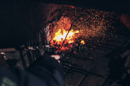 Blacksmith at work with glowing irons. Hot iron forge, a blacksmith at work with red-hot iron.の写真素材