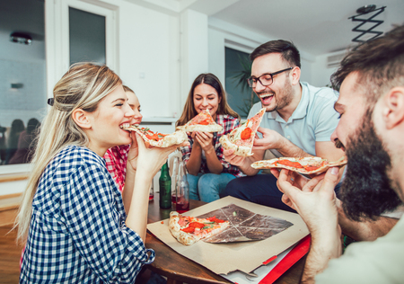 Group of young friends eating pizza.Home party.の写真素材
