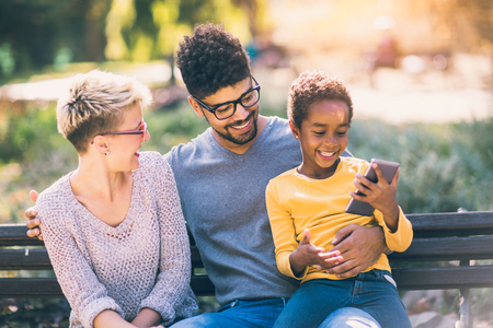 Happy young mixed race couple spending time with their daughterの写真素材
