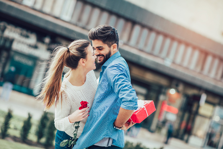 Romantic Man giving flower and gift box to woman for Valentines dayの写真素材