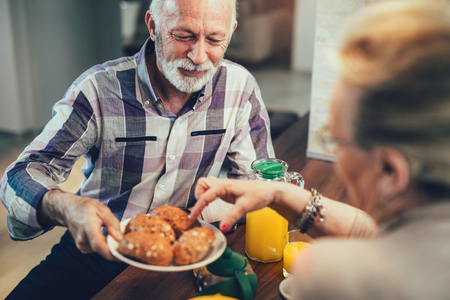 Elderly couple in the kitchen preparing breakfastの写真素材