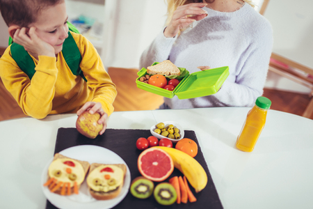 Mother making breakfast for her children in the morning and a snack for schoolの写真素材
