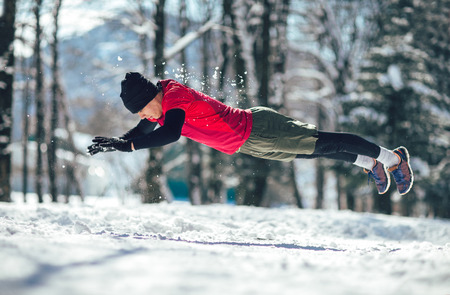 Young man in sporty wear alone working out on a winter dayの写真素材