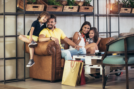  Family with two children having great time in a cafe after shoppingの写真素材