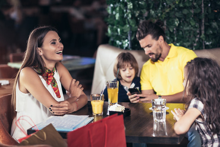  Family with two children having great time in a cafe after shoppingの写真素材