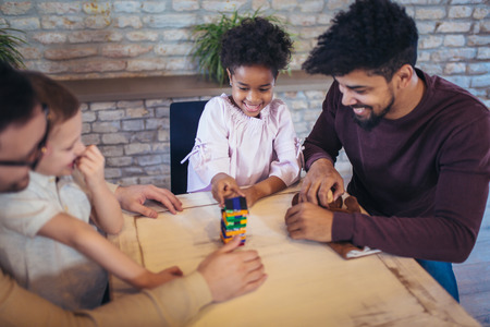 Two fathers play educational games with their children, having fun.