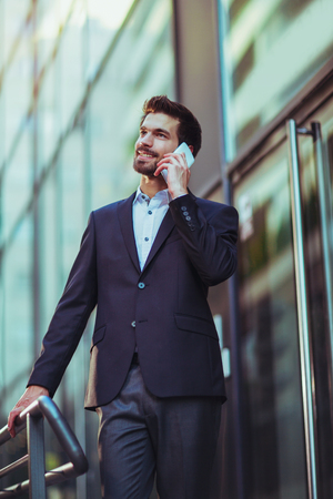 Young business man talking on his phone outdoors on a building background office center.
の写真素材