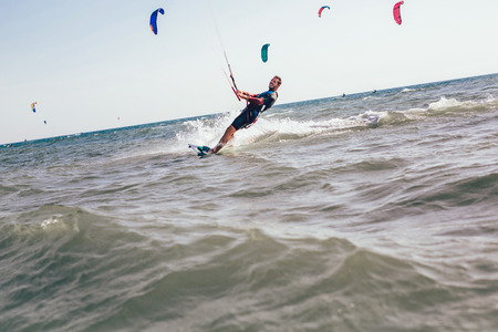 Kitesurfing Kiteboarding action photos man among waves quickly goes